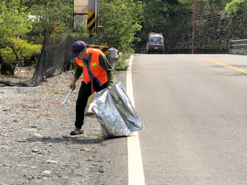 志工專注撿拾公路邊緣零散垃圾